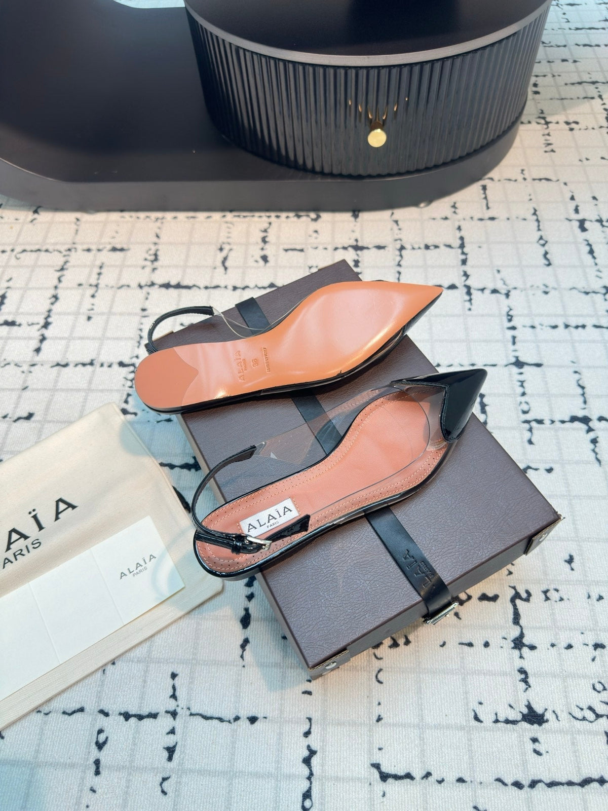 ALAIA FLAT SLINGBACK IN BLACK PATENT CALFSKIN AND FILM