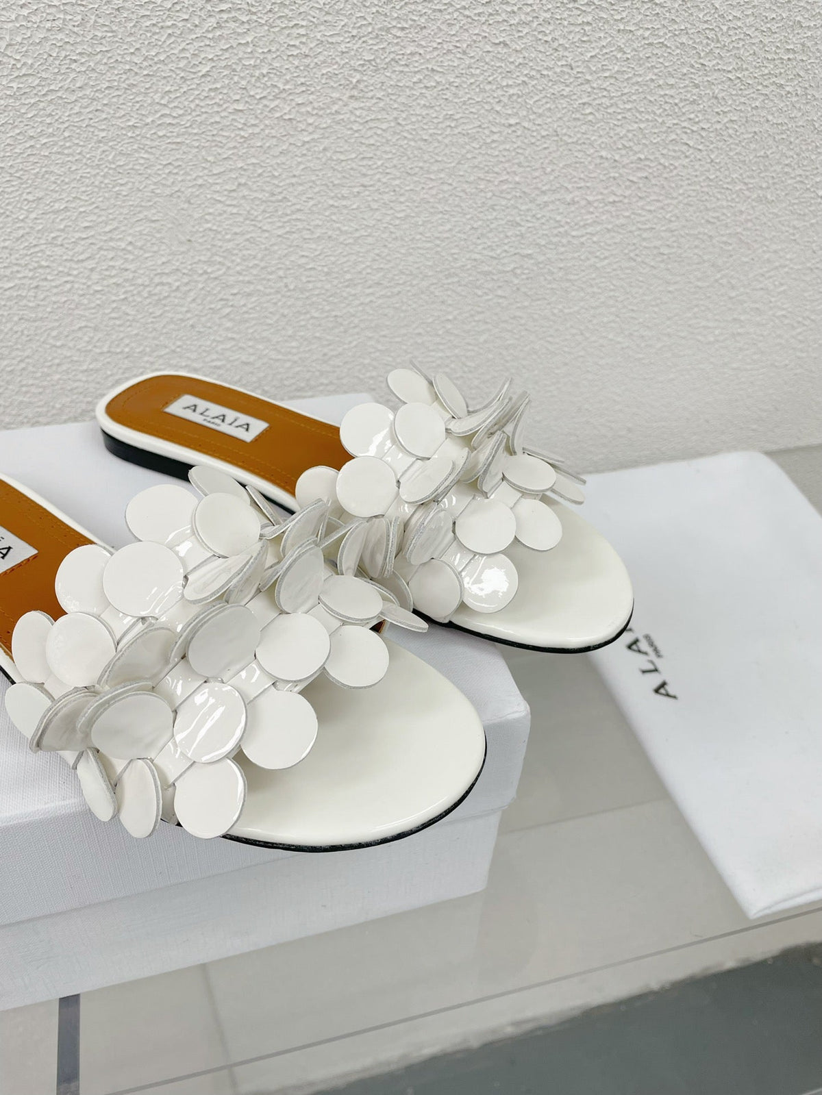 ALAIA FLAT MULE IN WHITE GLOSSY LAMBSKIN