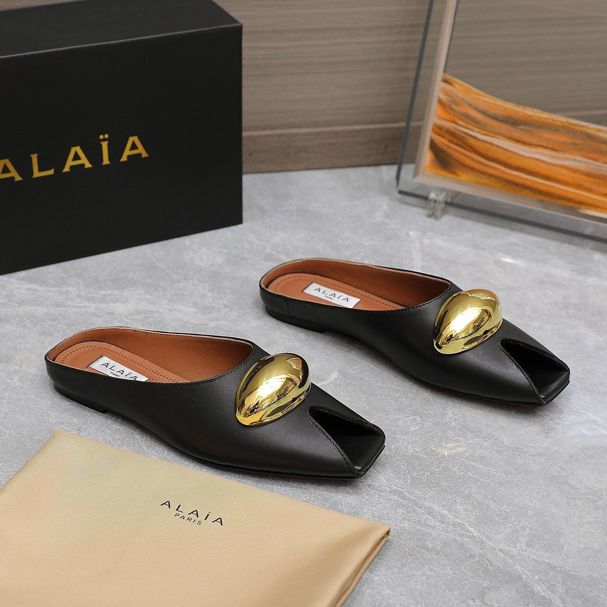 ALAIA FLAT MULE IN BLACK LAMBSKIN WITH GOLD HARDWARE