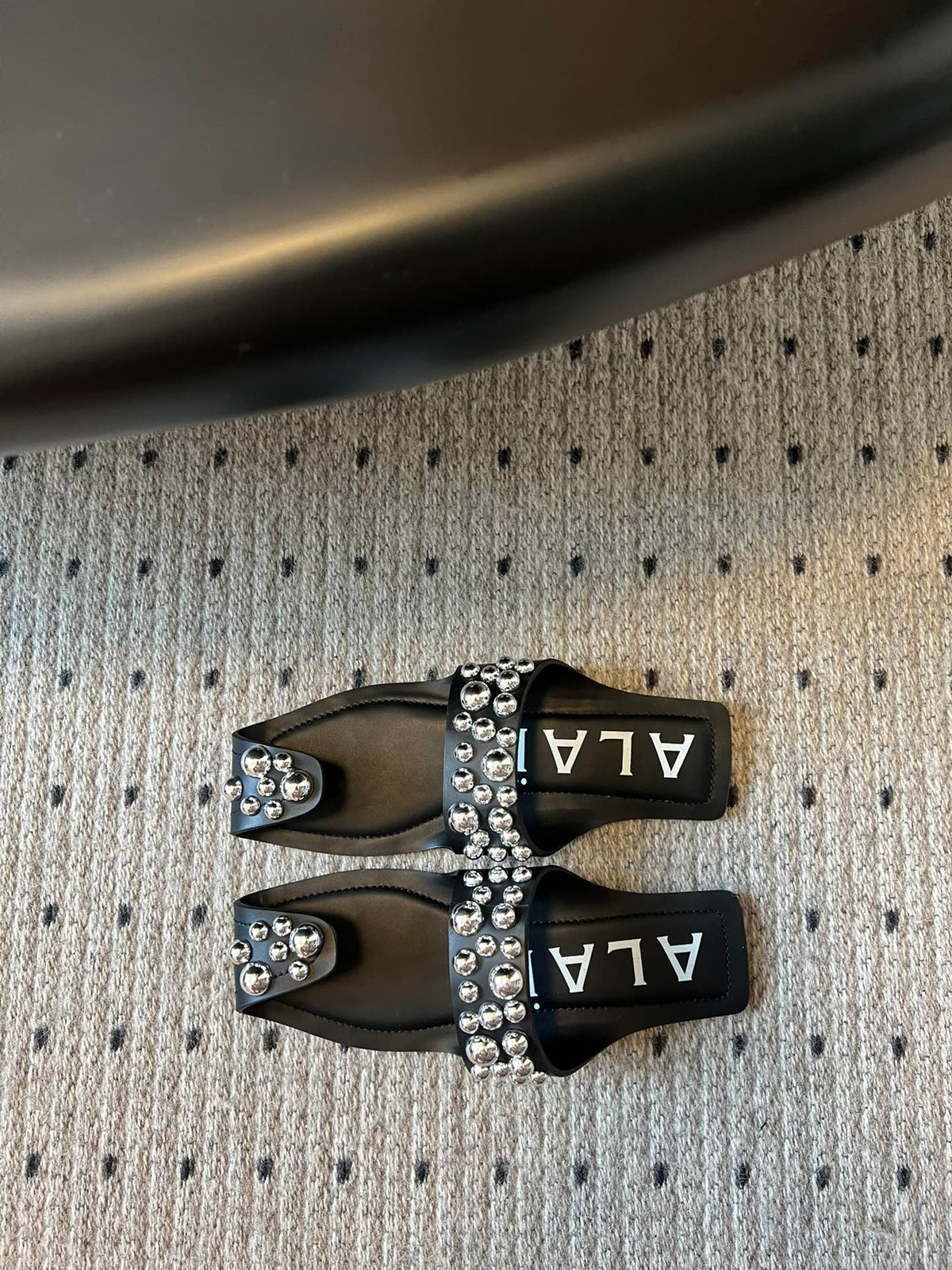 ALAIA FOLDED FLAT MULES WITH SPHERES ON BLACK CALFSKIN