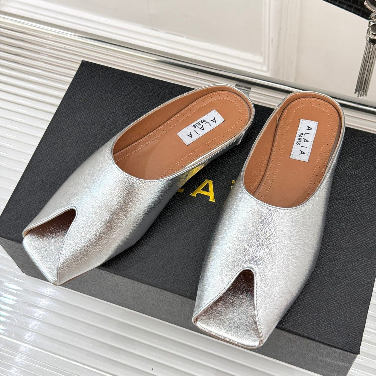 ALAIA FLAT MULE IN SILVER LAMBSKIN