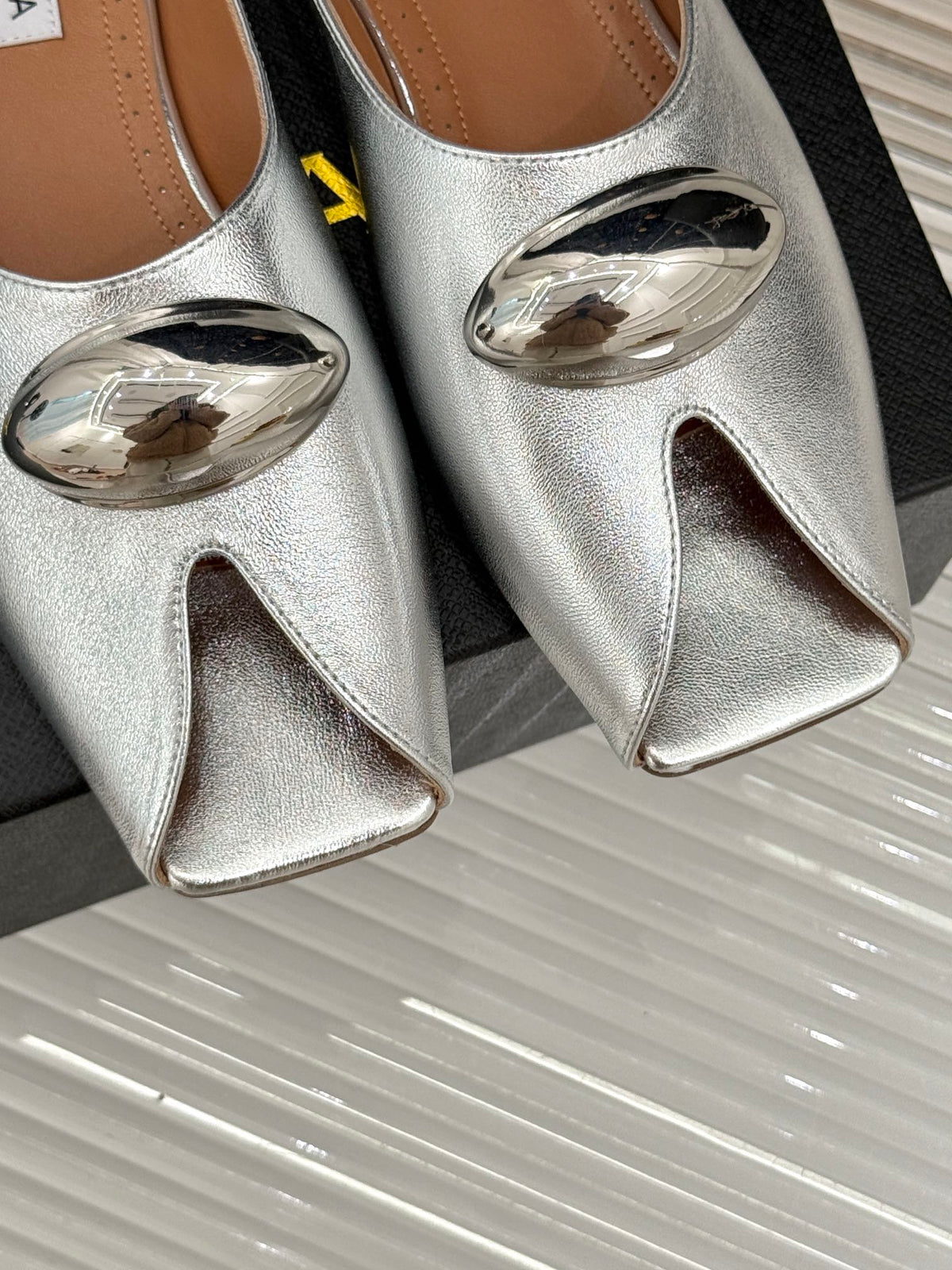 ALAIA FLAT MULE IN SILVER LAMBSKIN WITH SILVER HARDWARE