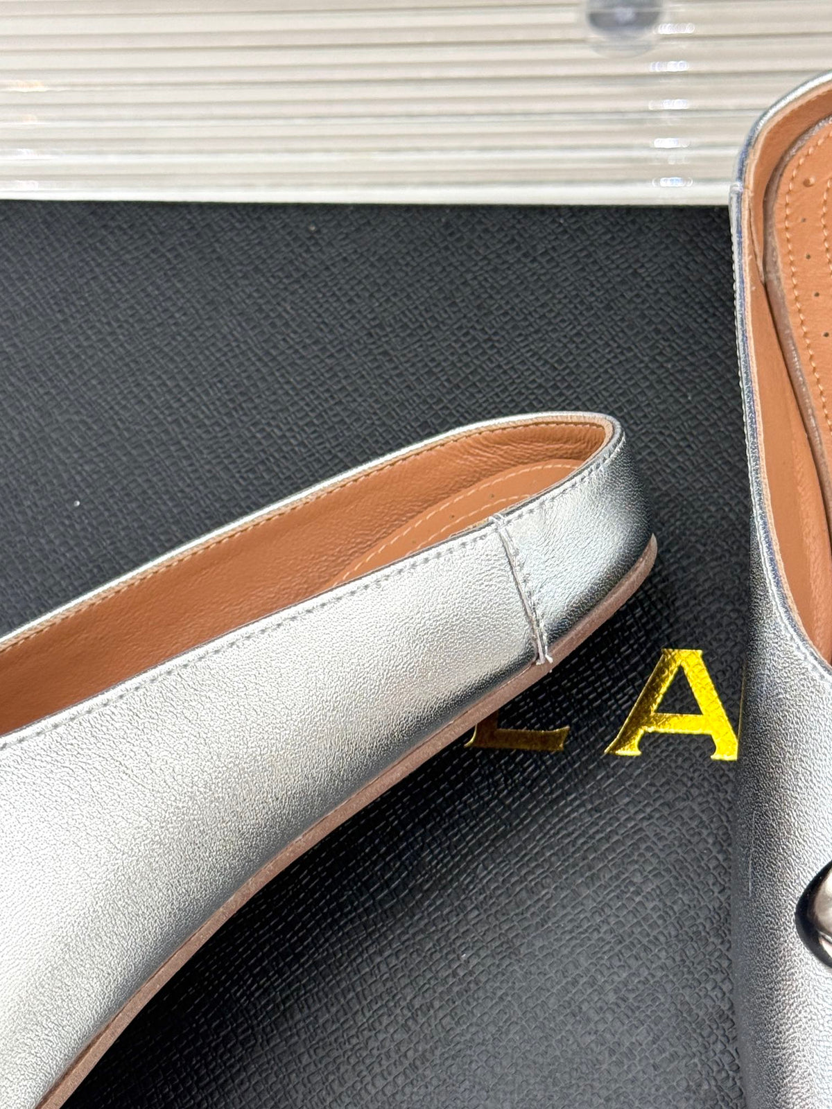 ALAIA FLAT MULE IN SILVER LAMBSKIN WITH SILVER HARDWARE