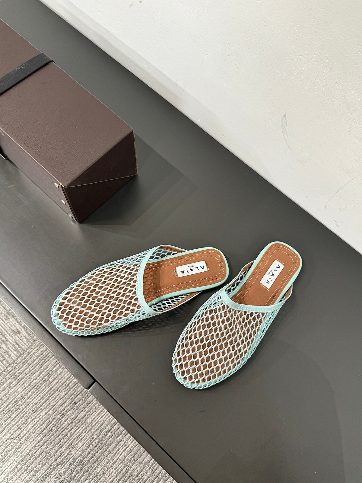 ALAIA FLAT MULES IN LIGHT BLUE MESH FISHNET