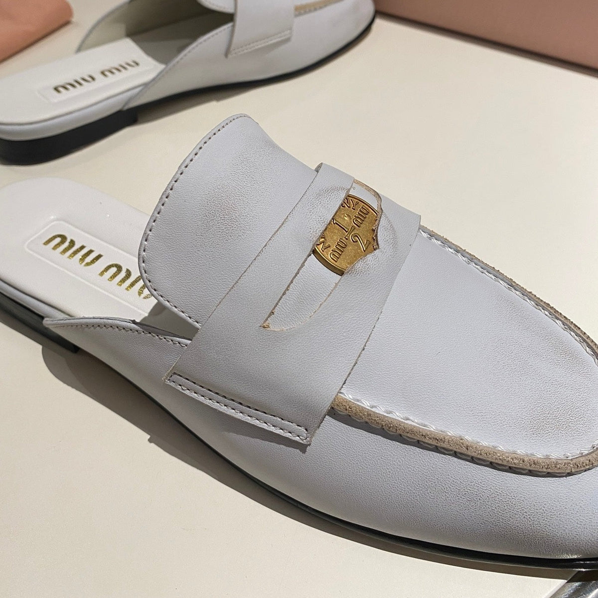MULES SLIPPERS WHITE COWHIDE WITH GOLD COIN
