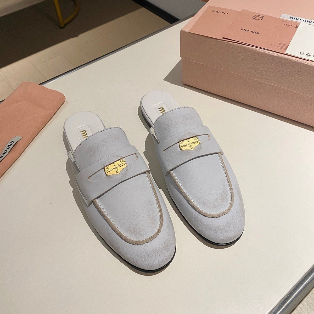 MULES SLIPPERS WHITE COWHIDE WITH GOLD COIN