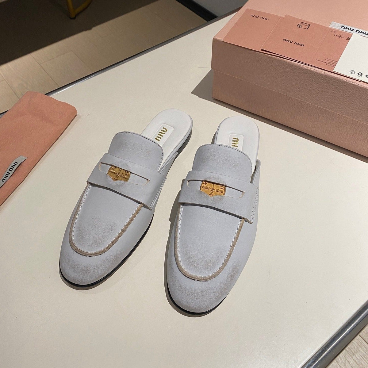 MULES SLIPPERS WHITE COWHIDE WITH GOLD COIN