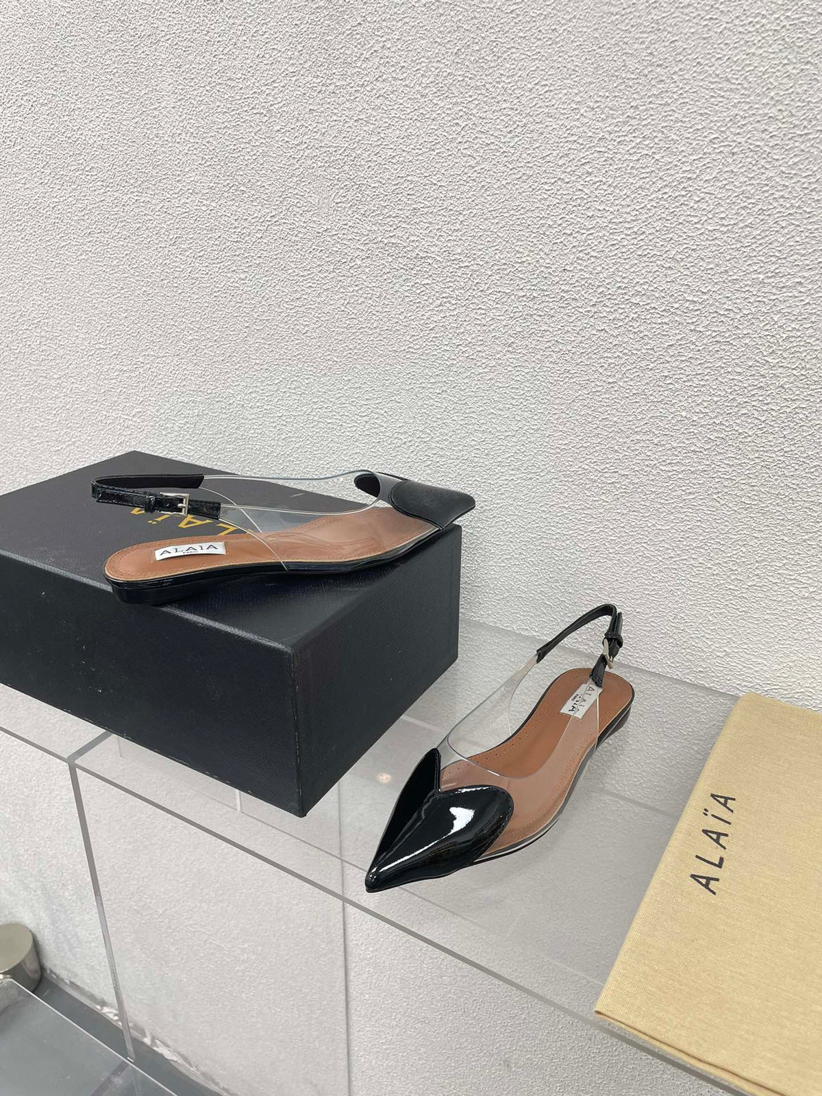 ALAIA LE COEUR FLAT SLINGBACKS IN BLACK PATENT LAMBSKIN