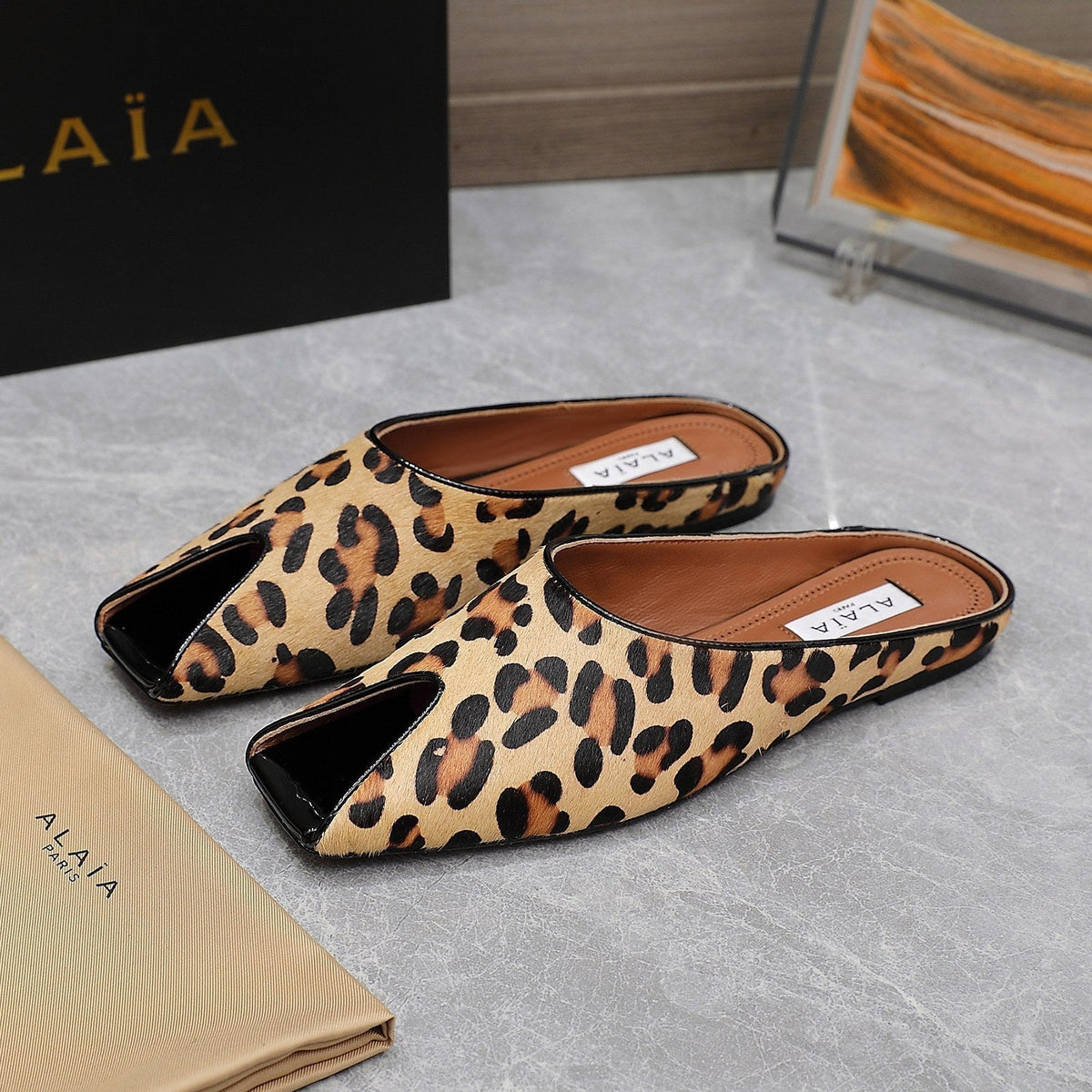 ALAIA FLAT MULE IN LEOPARD LAMBSKIN