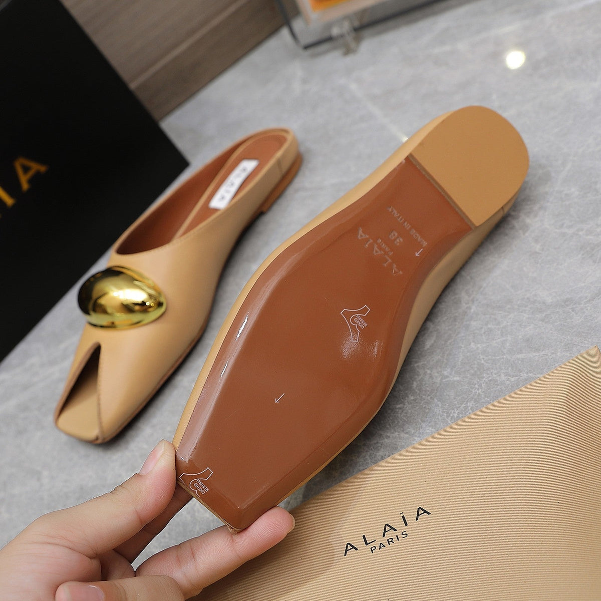 ALAIA FLAT MULE IN SEPIA TAN LAMBSKIN WITH GOLD HARDWARE