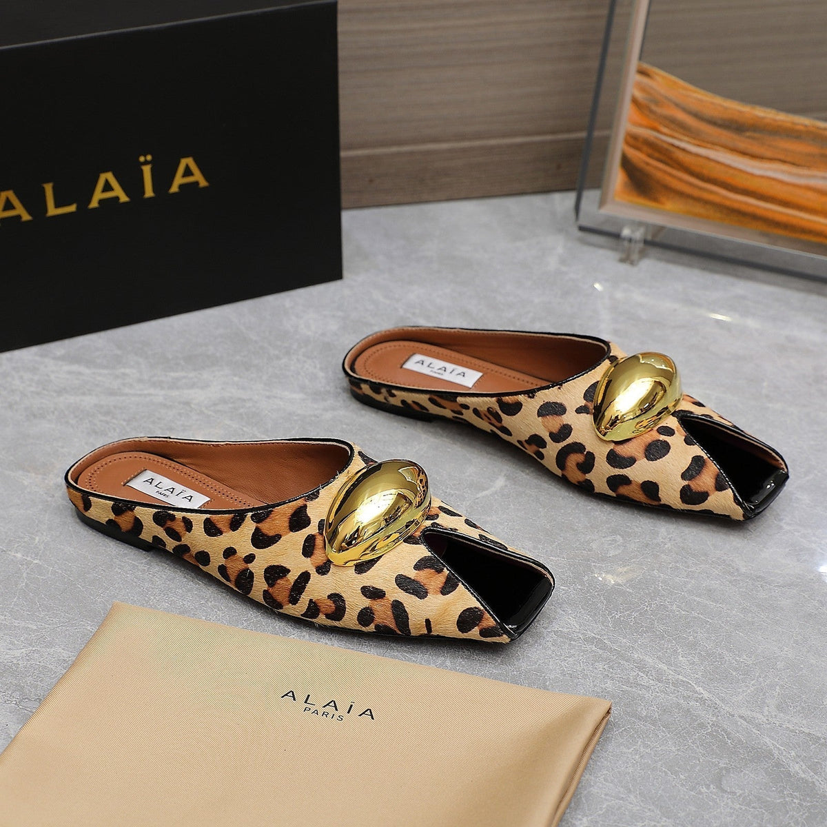 ALAIA FLAT MULE IN LEOPARD LAMBSKIN WITH GOLD HARDWARE