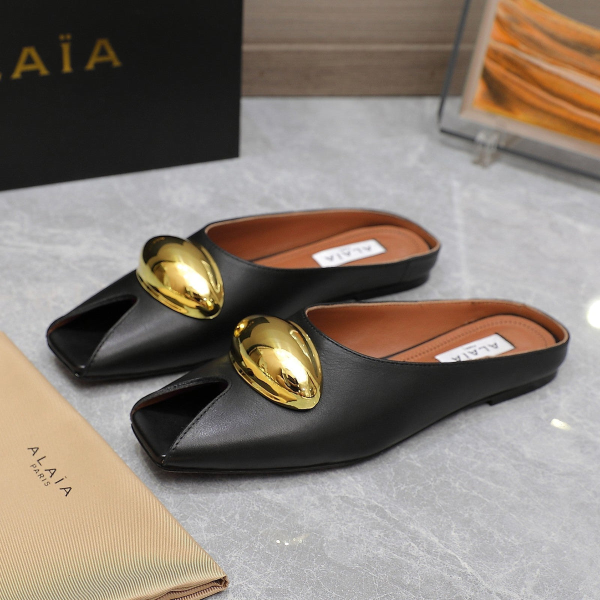 ALAIA FLAT MULE IN BLACK LAMBSKIN WITH GOLD HARDWARE