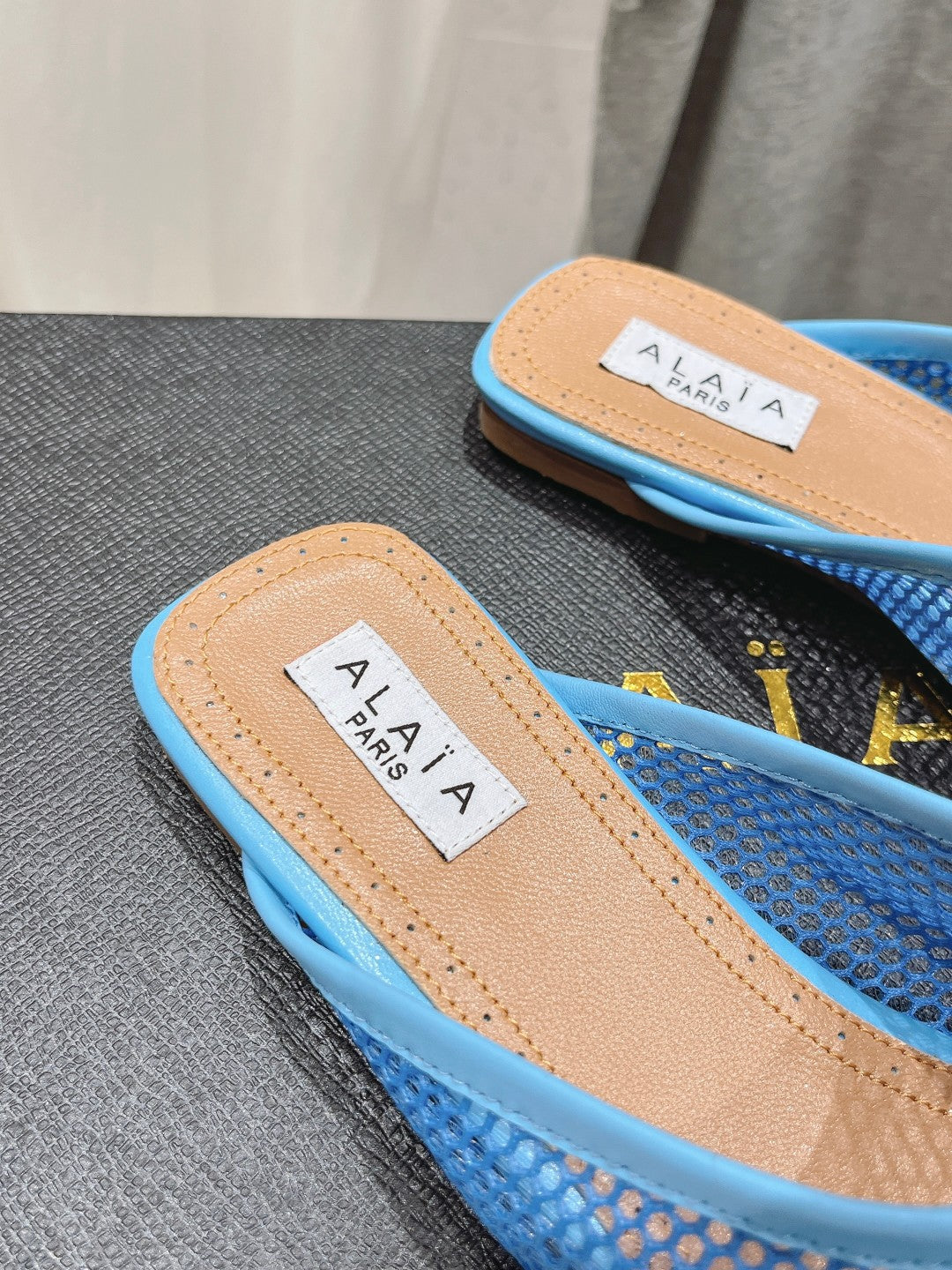 ALAIA FLAT MULES IN CERULEAN BLUE MESH FISHNET